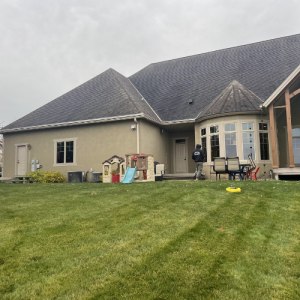 House with grey roof and beige siding with a softscape landscaping design in Middleton, WI