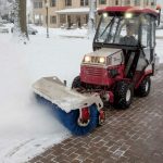 Carrington Lawn & Landscape crew on a power broom in a process of snow and ice management